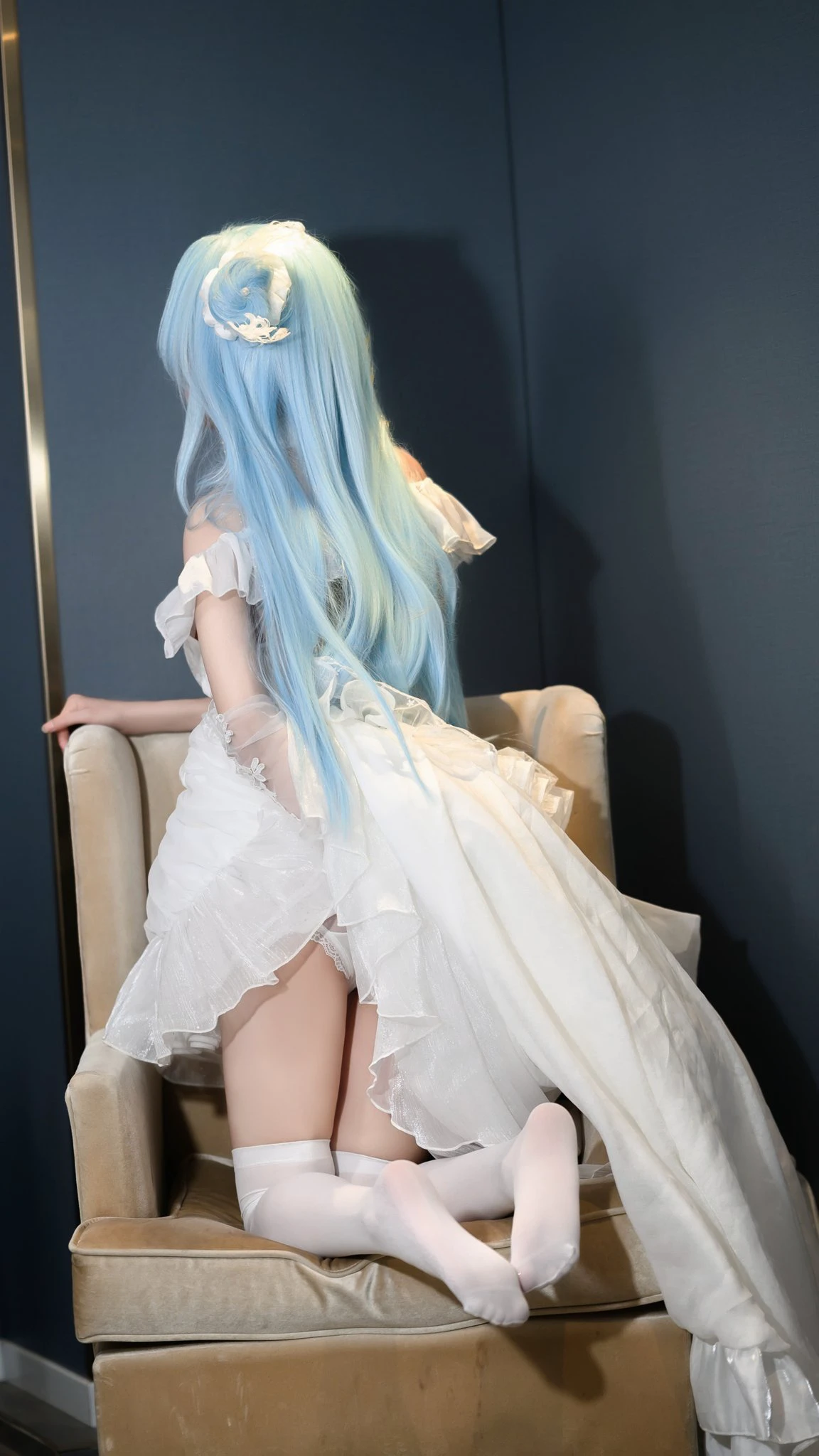 蓝色长发白裙少女坐在沙发上