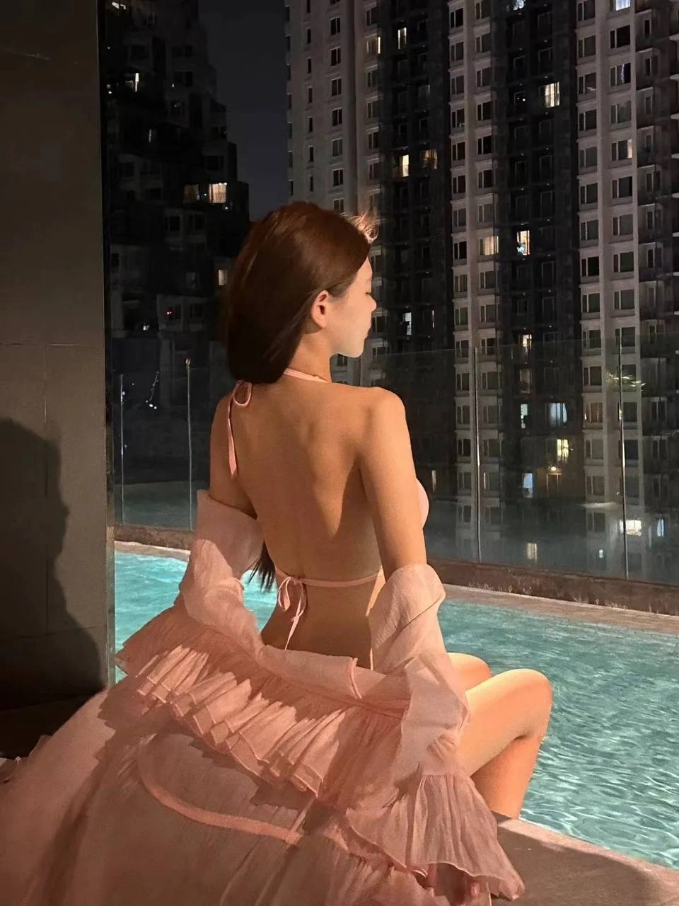 一个穿比基尼的女人坐在沙发上,看着相机。