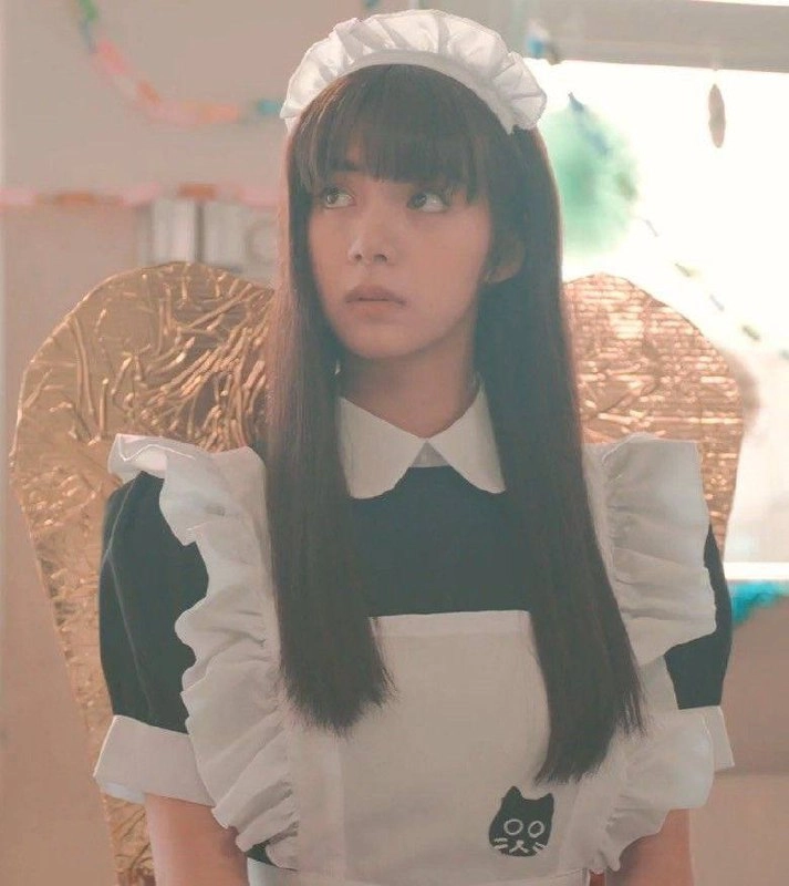 女士穿着女仆的服装,她的衬衫上有一只黑猫。