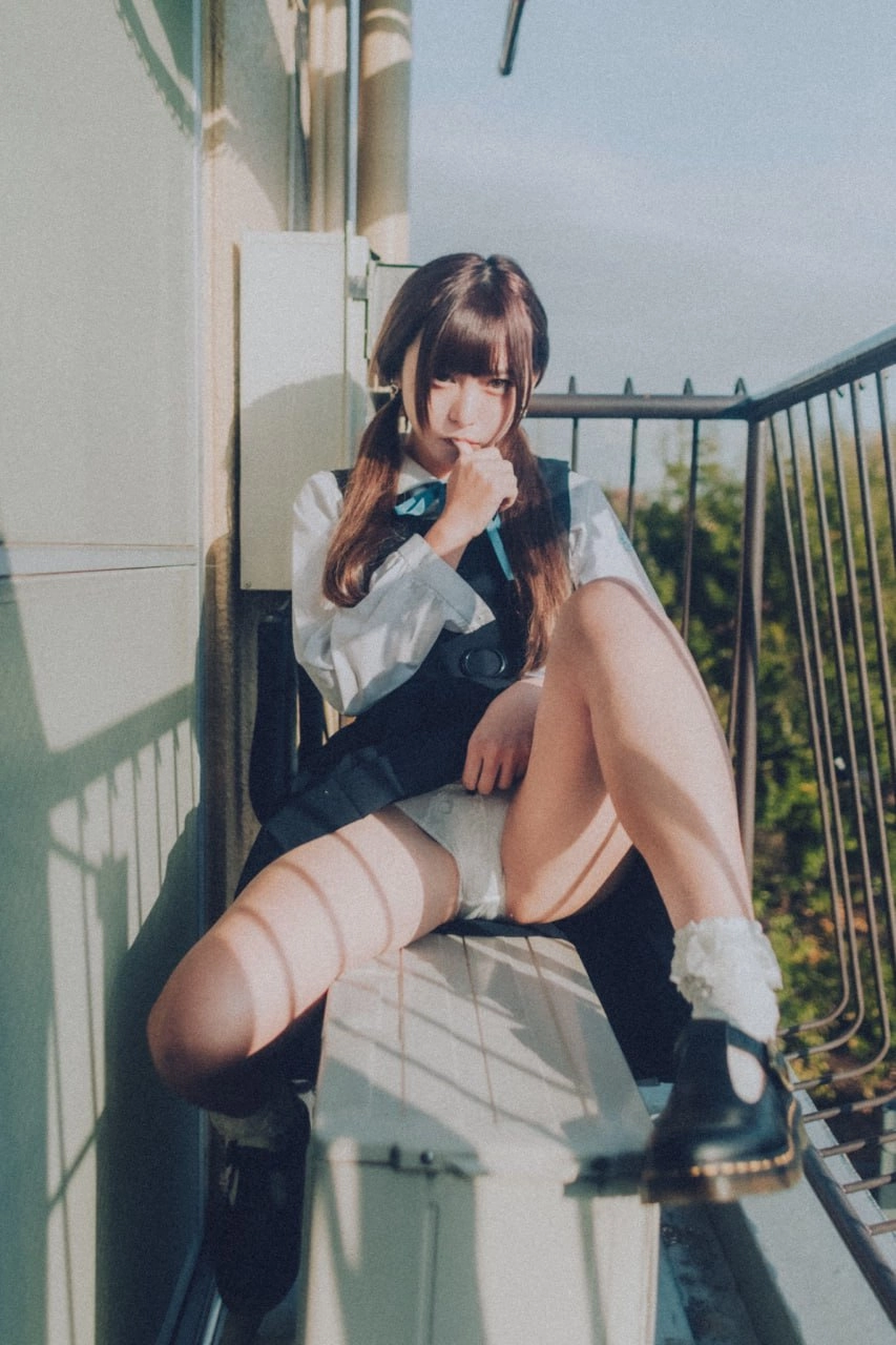 带着马尾巴和蓝弓的女孩坐在一个凳子上。