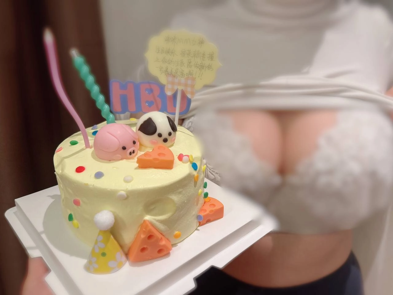 女人拿着粉红色和白色的生日蛋糕。