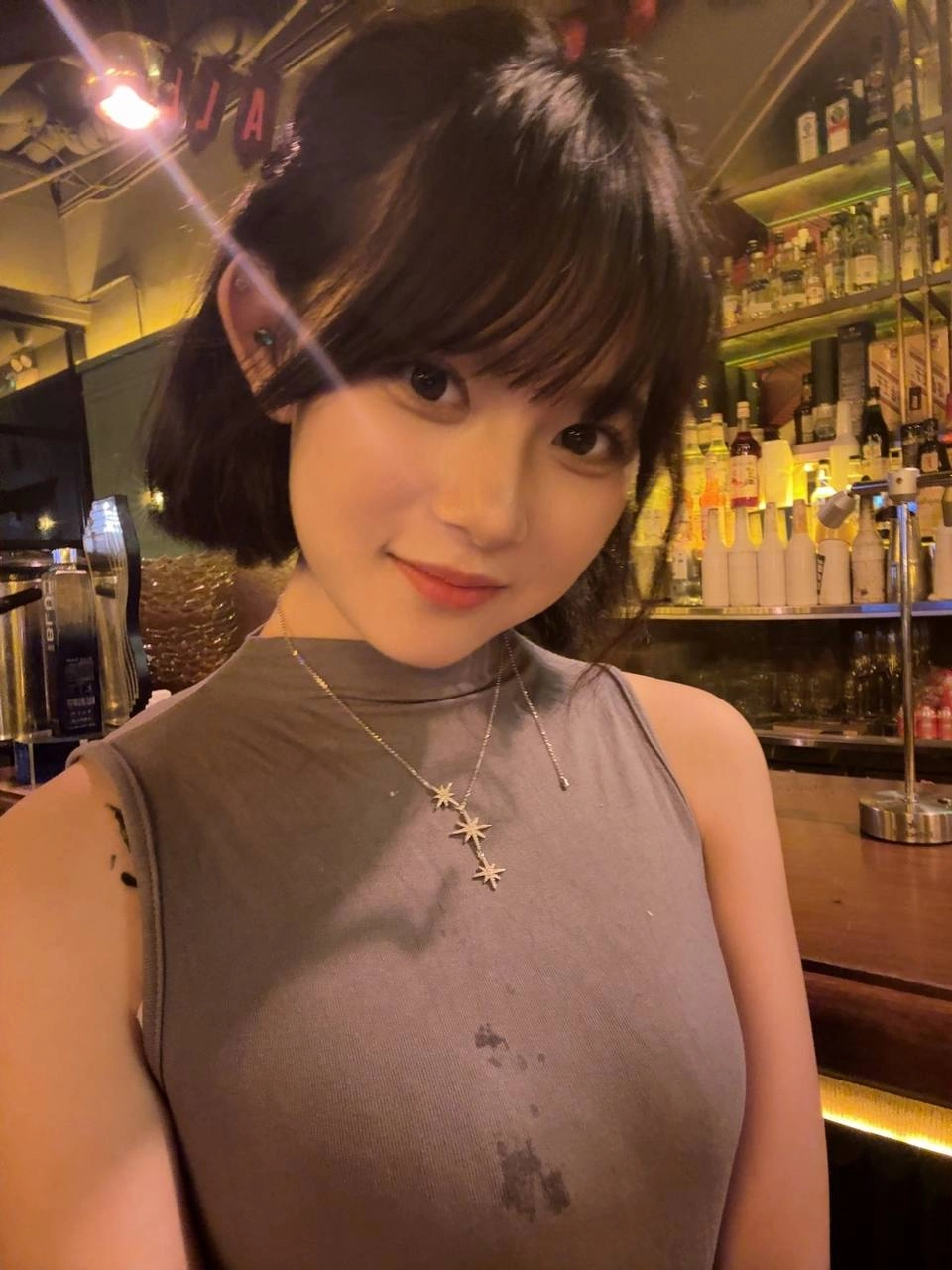 穿着灰色的衬衫和项链的女人。