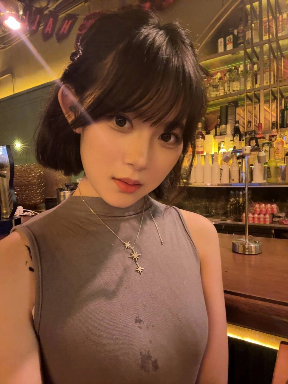 穿着灰色的衬衫和项链的女人。