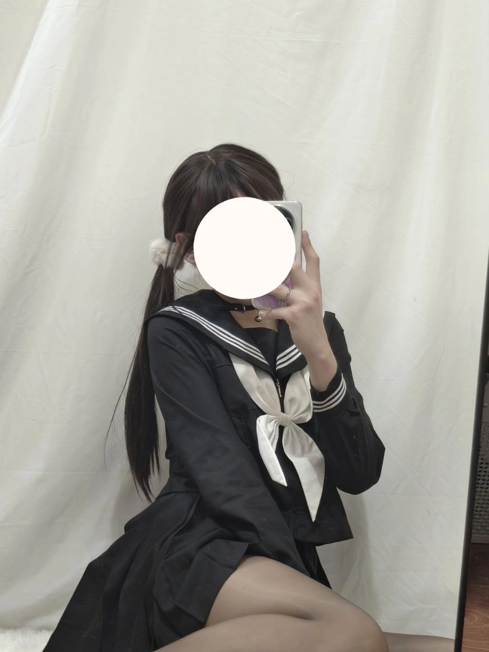 一位穿着黑色和白色的水手服的女人拍了一张自拍。