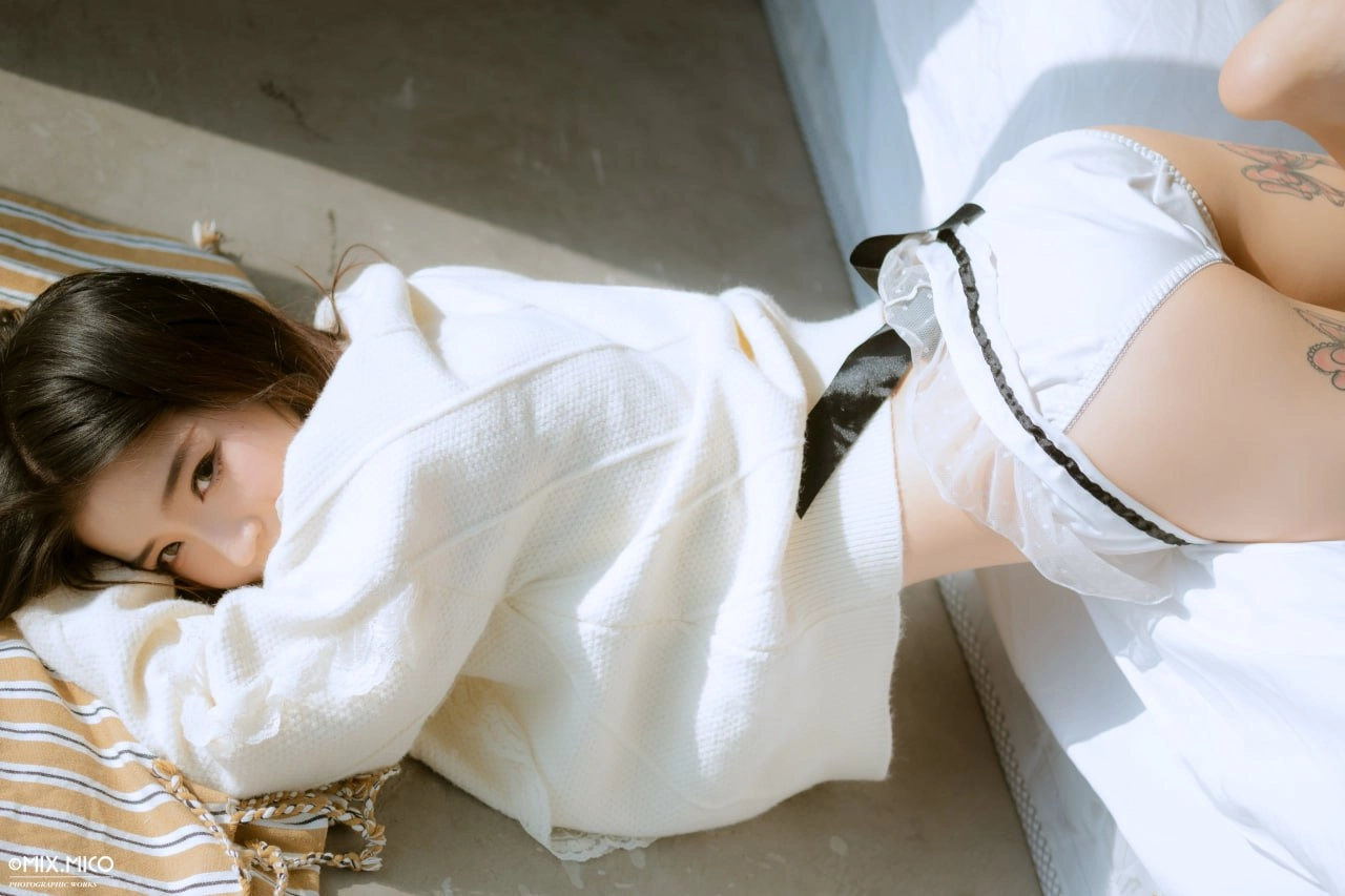 有纹身的女人躺在床上。