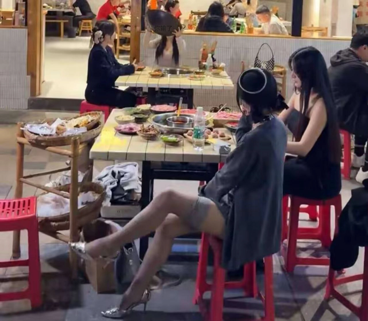 两个女人坐在餐厅的桌子上。