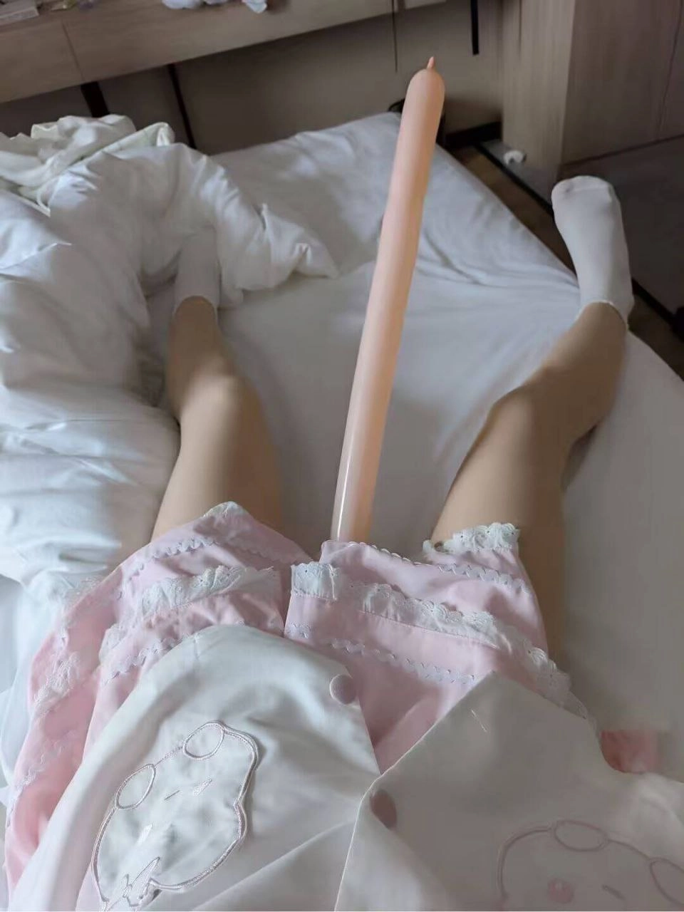 人躺在床上,有一个巨大的粉红色阴茎。