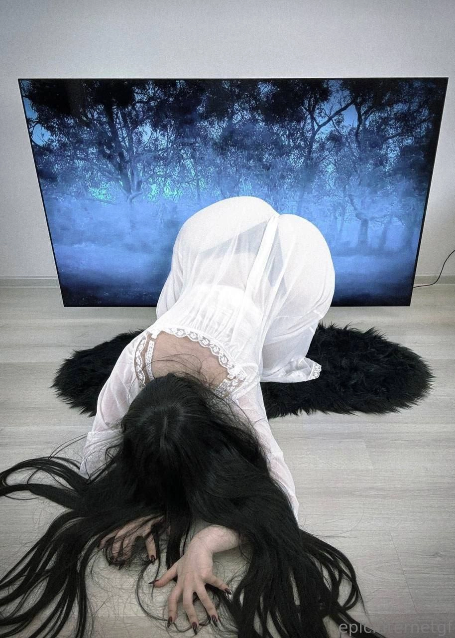 女人跪在电视前。