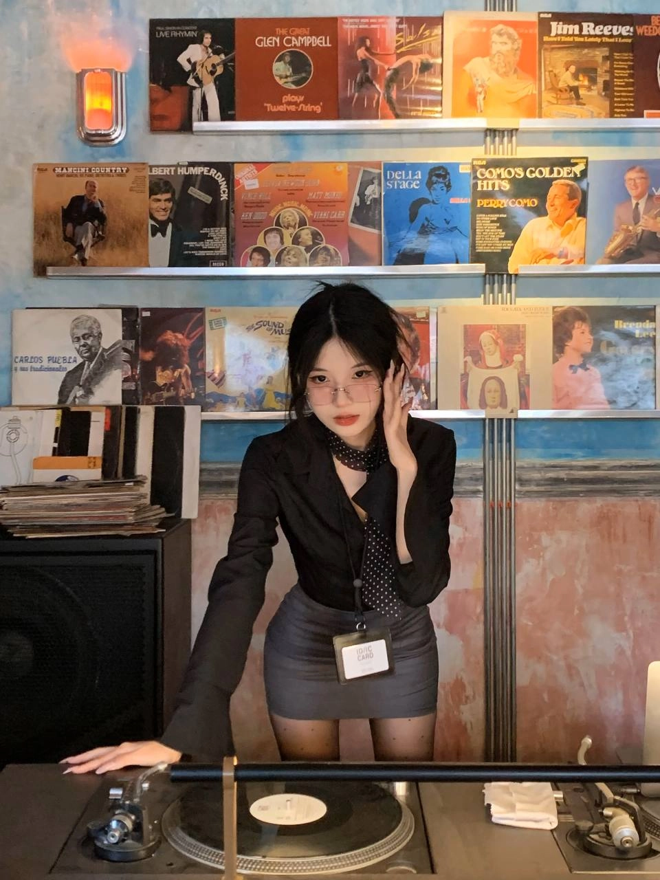 一位穿着黑色衬衫和领带的女人用一系列娃娃展现。