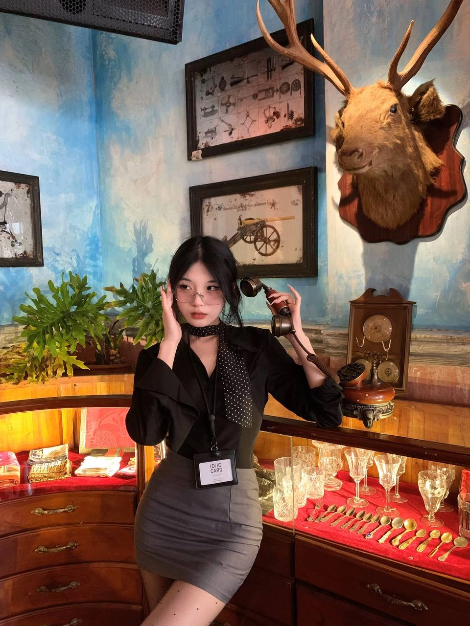 一位穿着黑色衬衫和领带的女人用一系列娃娃展现。