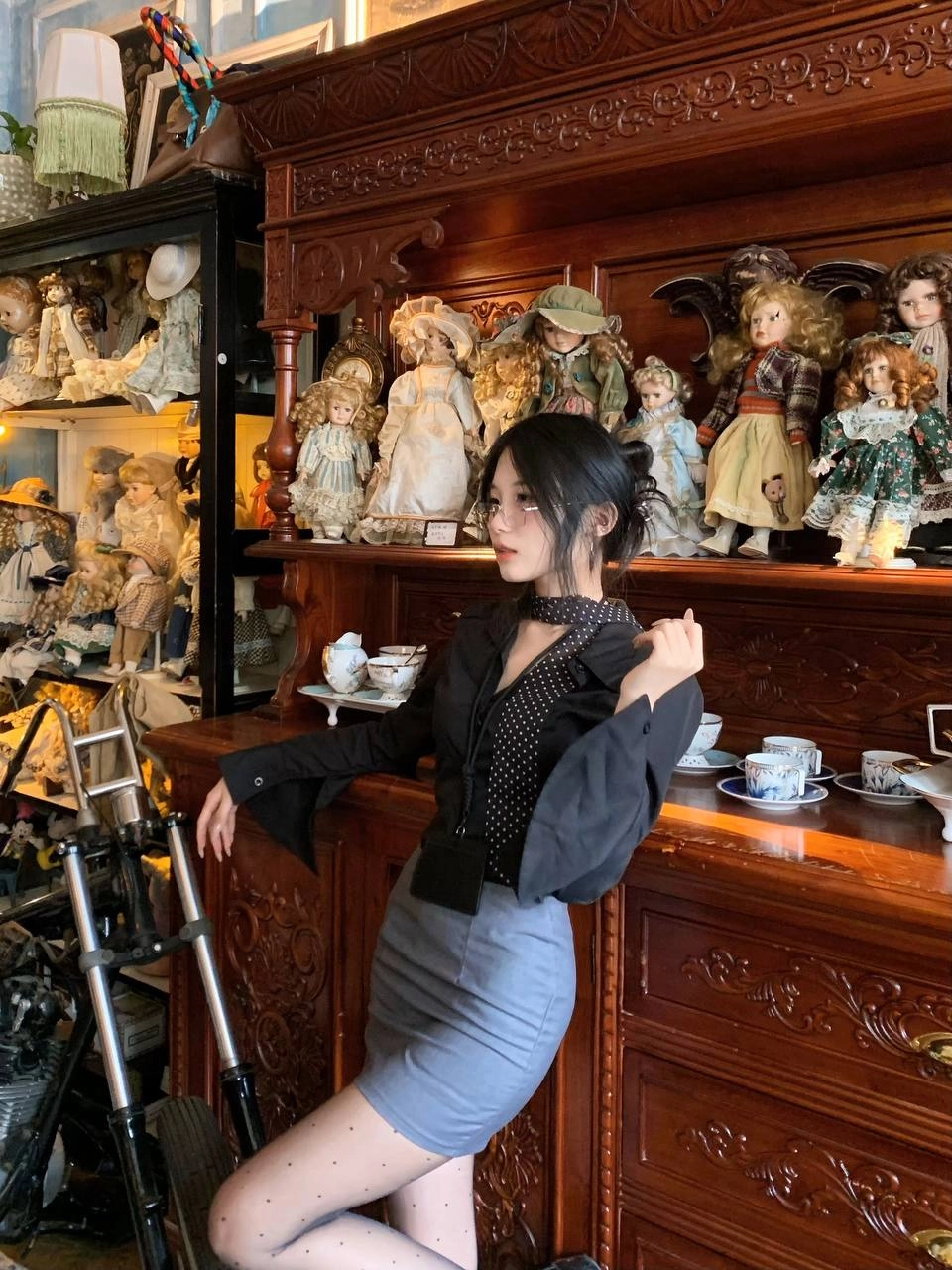 女人站在一个娃娃收藏的面前。