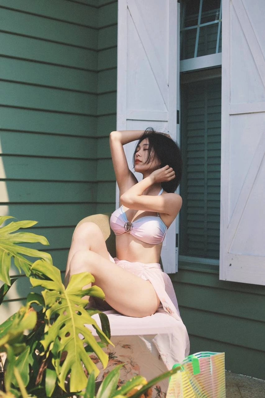 穿着比基尼的女人坐在一个凳子上。