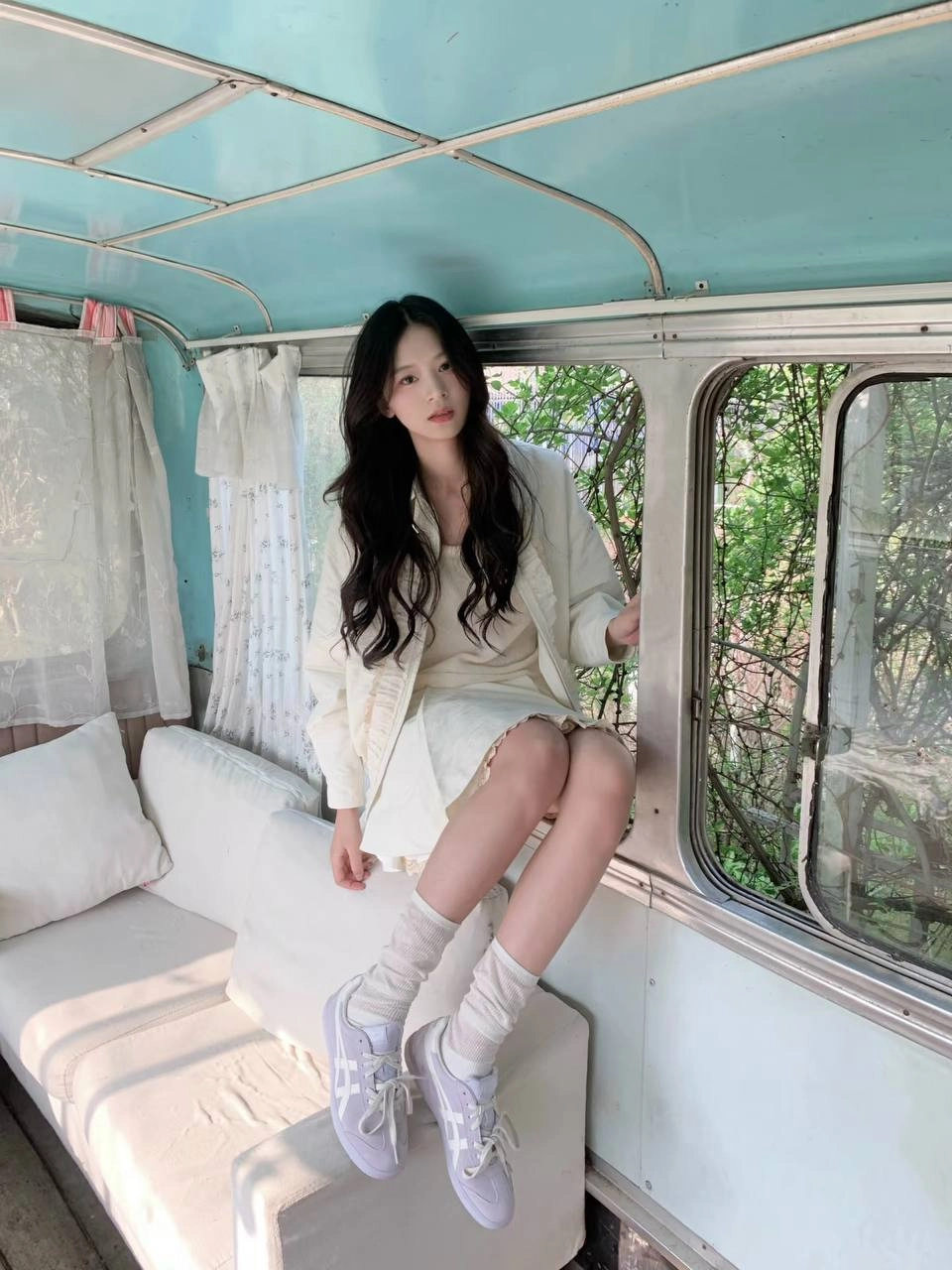 一位穿着白色袜子和白色裙子的女人坐在凳子上。