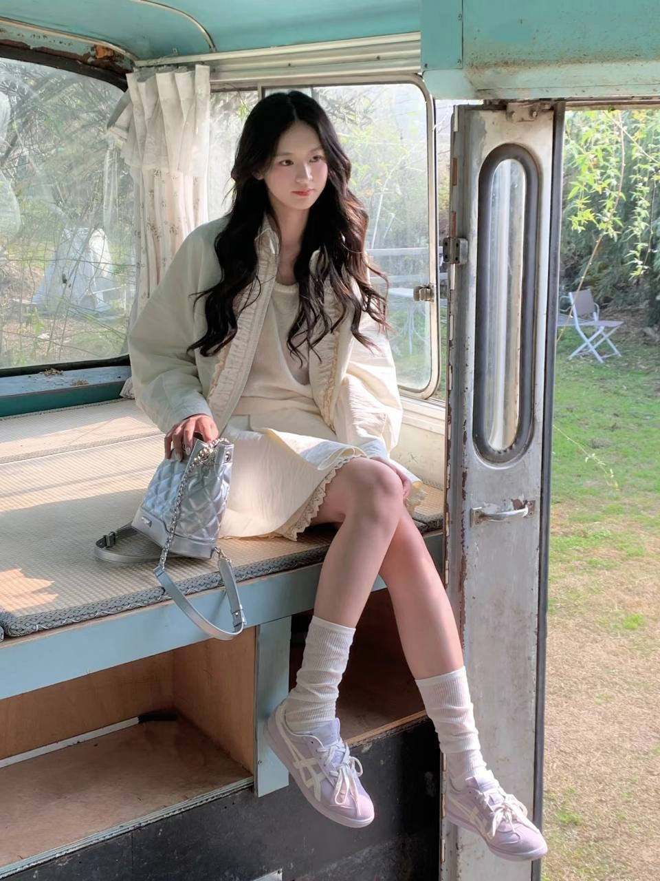 一位穿着白色袜子和白色裙子的女人坐在凳子上。