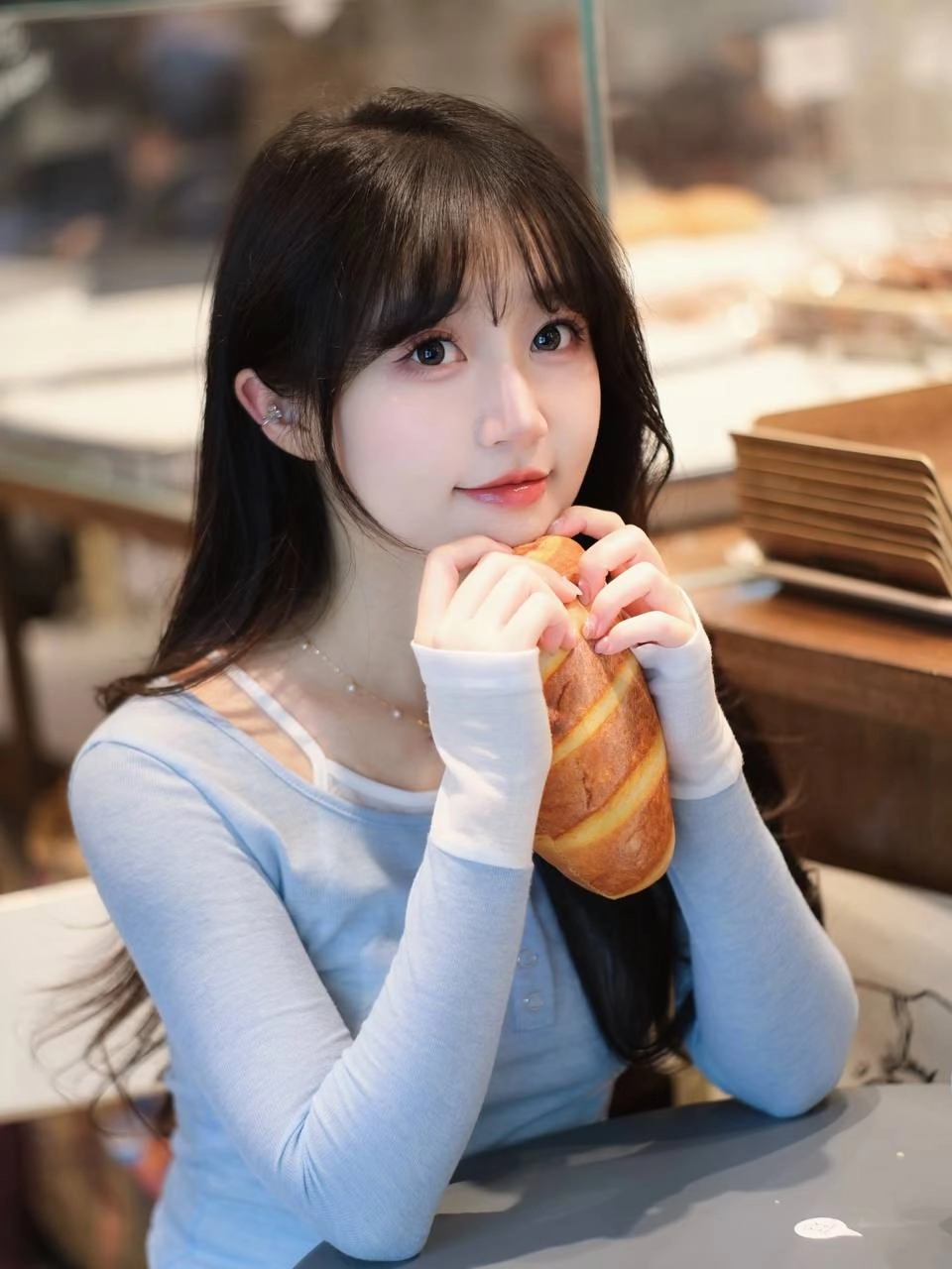 长头发和蓝衬衫的女人拿着一个杯子。