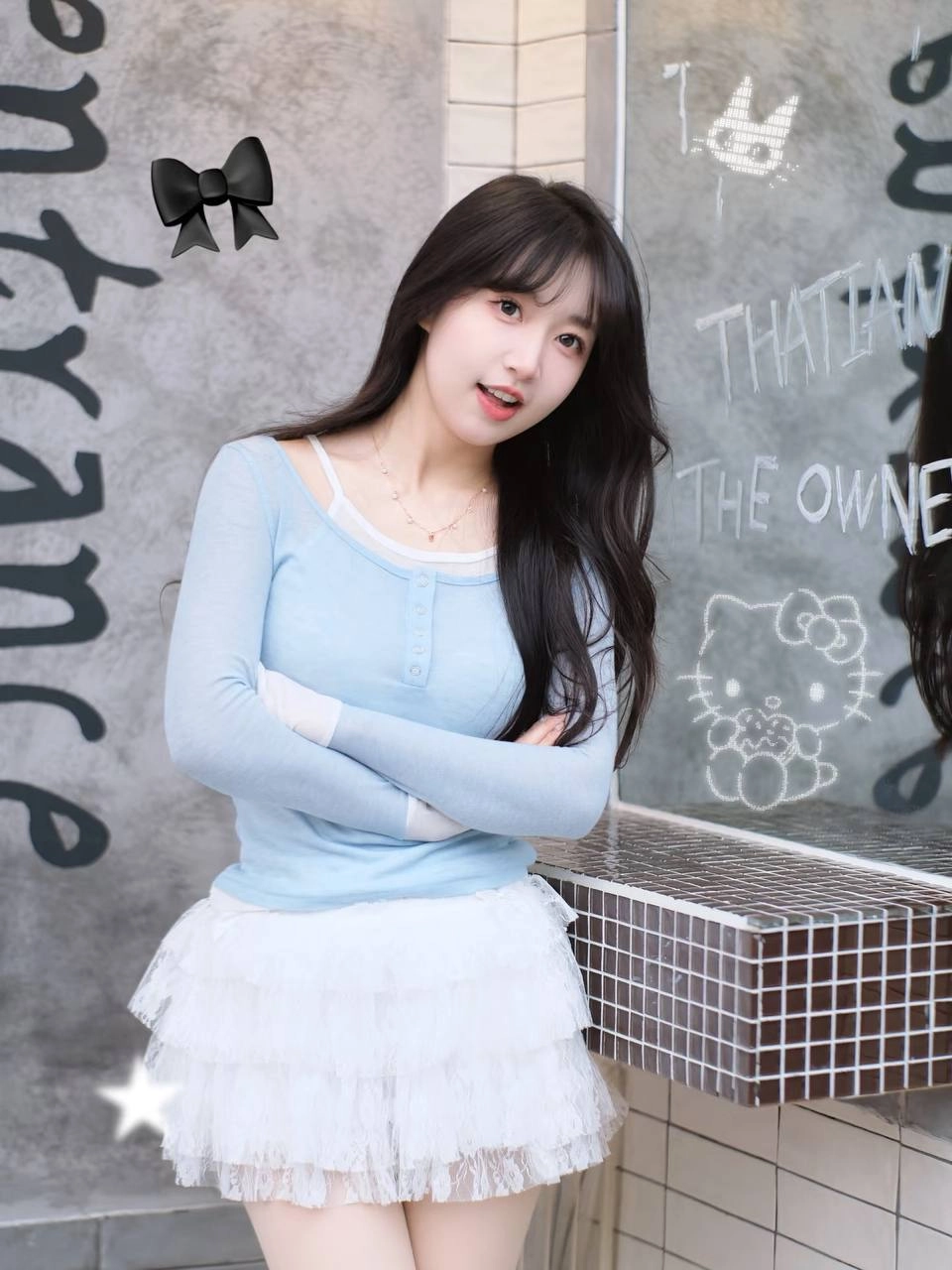 长头发和蓝衬衫的女人拿着一个杯子。