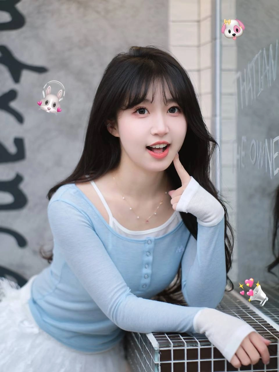 长头发和蓝衬衫的女人拿着一个杯子。