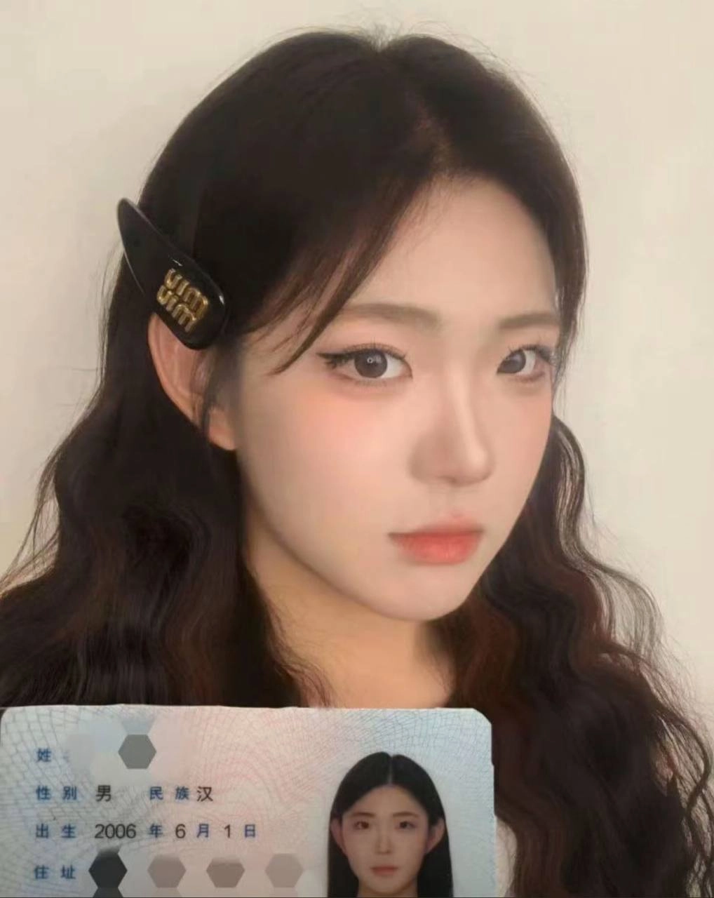 女人手里拿着一张黑色的头发和一张白色的卡片。