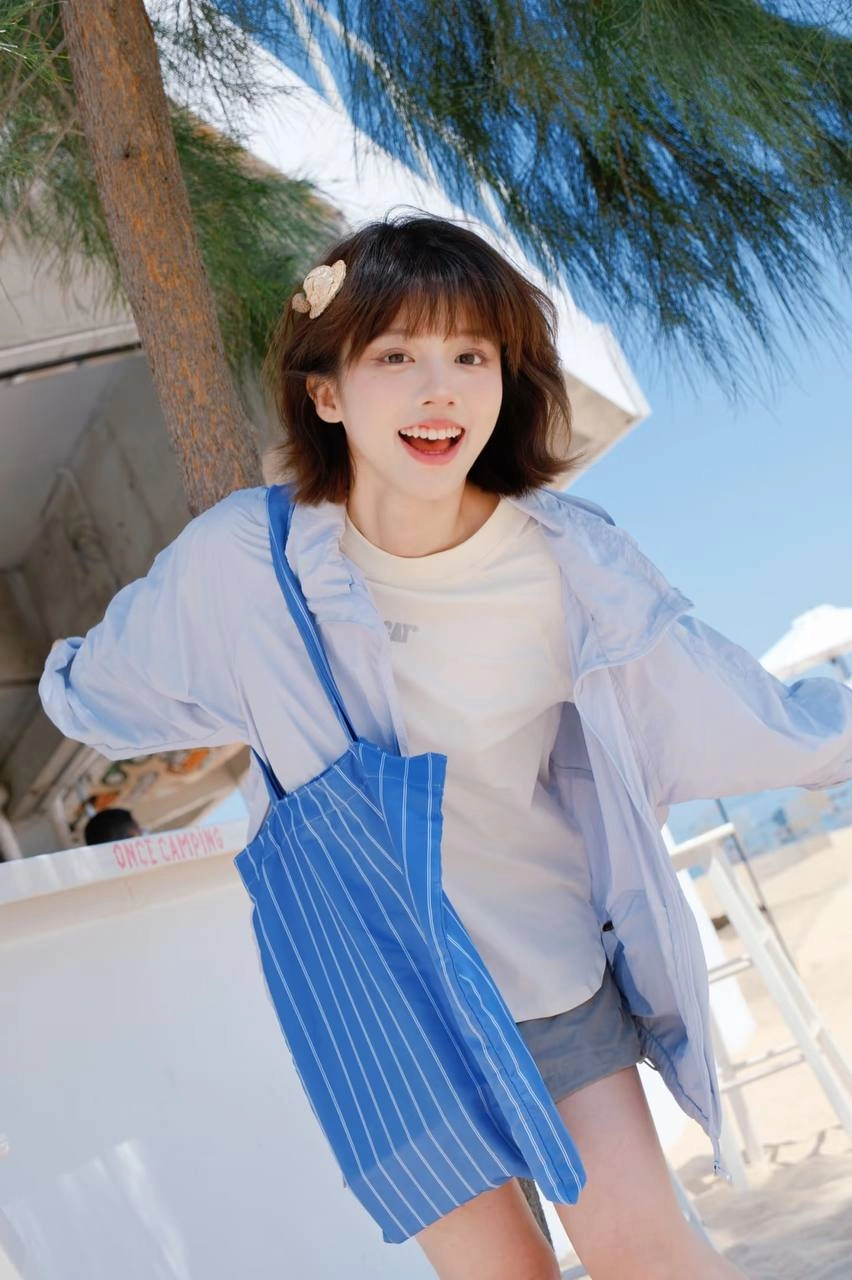 女人穿着蓝色夹克和丝带衬衫倾斜在一个柜台上。