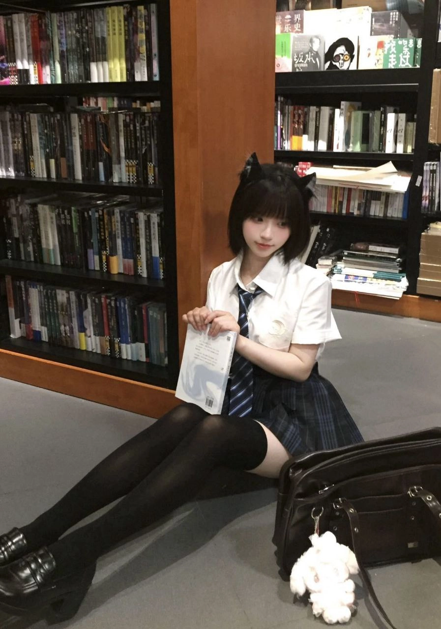 女孩坐在地板上,手里拿着一本书。