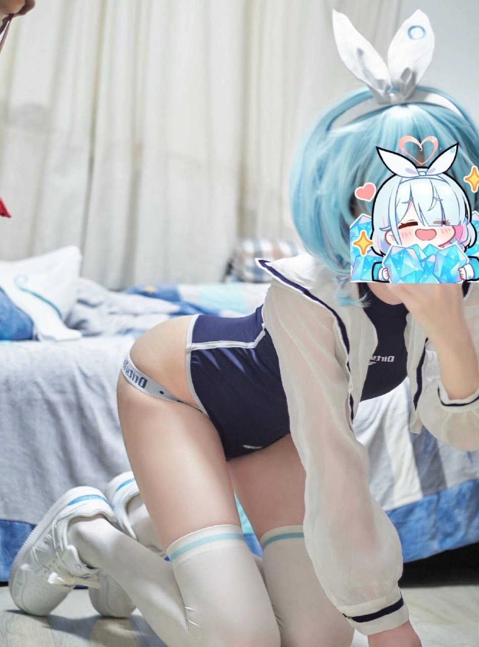 一位穿着蓝色西装的女人坐在床上。