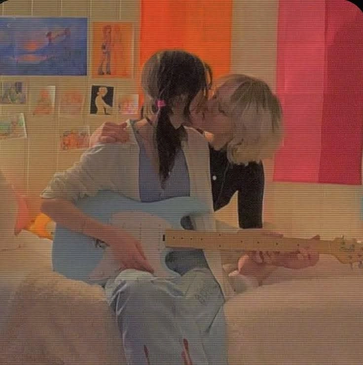 两个女孩接吻,拿着吉他。