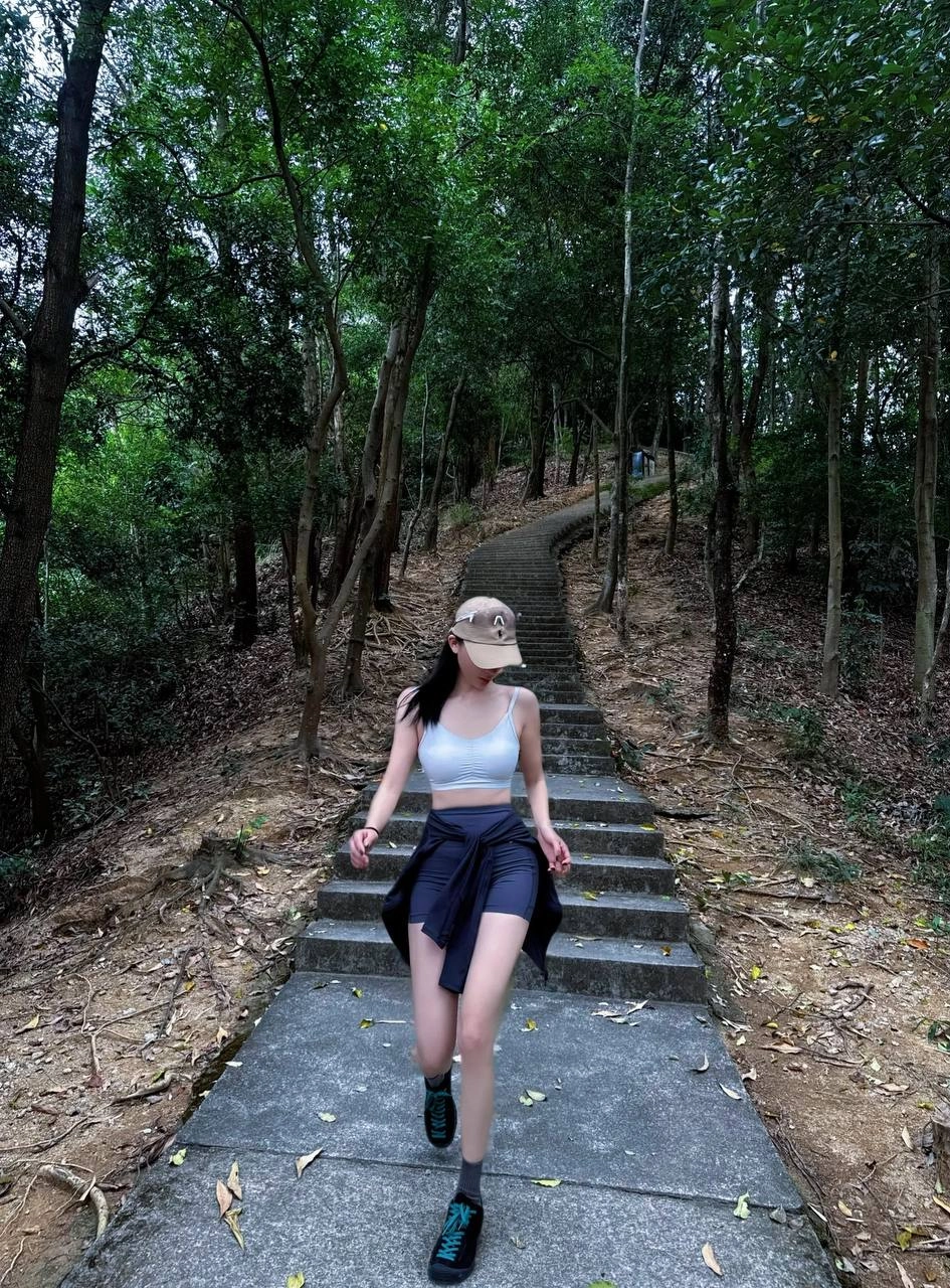 一位穿着棕色帽子和黑色短裤的女人在路上滑板。