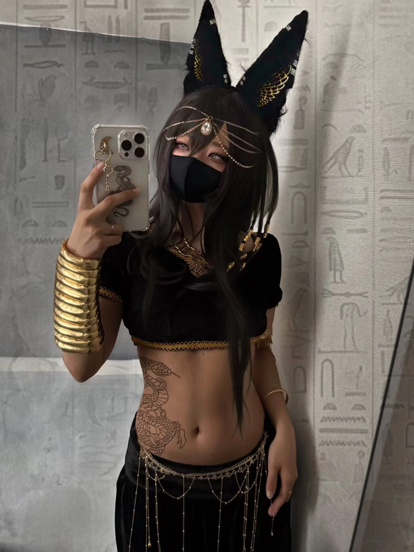 一位穿着黑色衬衫和黄金手的女人在镜子前拍自拍。