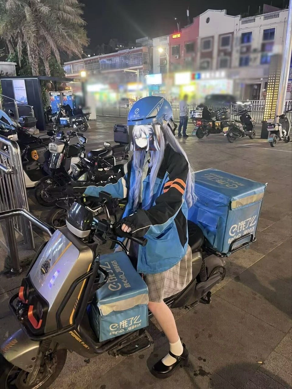 一位穿着头盔和蓝色夹克的女人骑着摩托车。