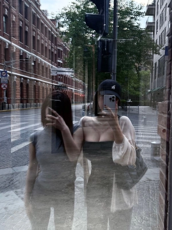 两个女人在交通灯前拍自拍。