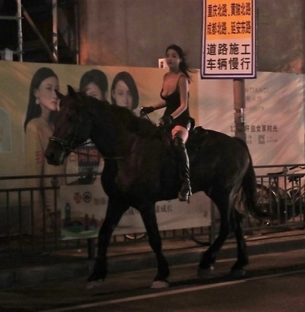 女人在街上骑马。