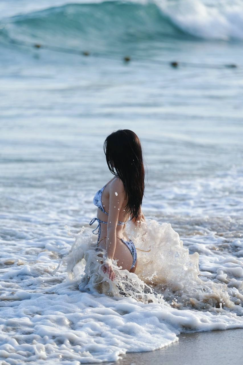 穿比基尼的女人站在海滩上。