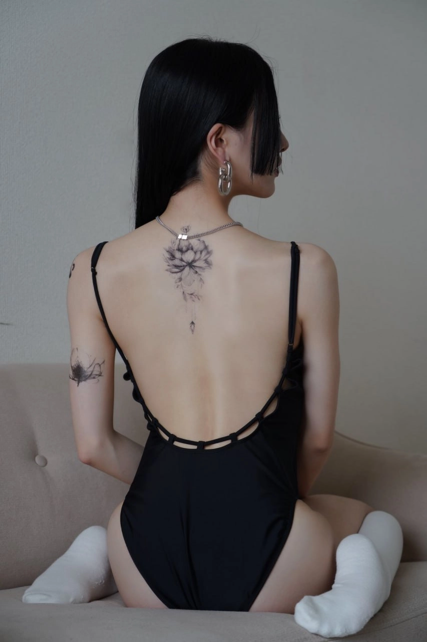 背上有纹身的女人穿着一件黑色的裙子。