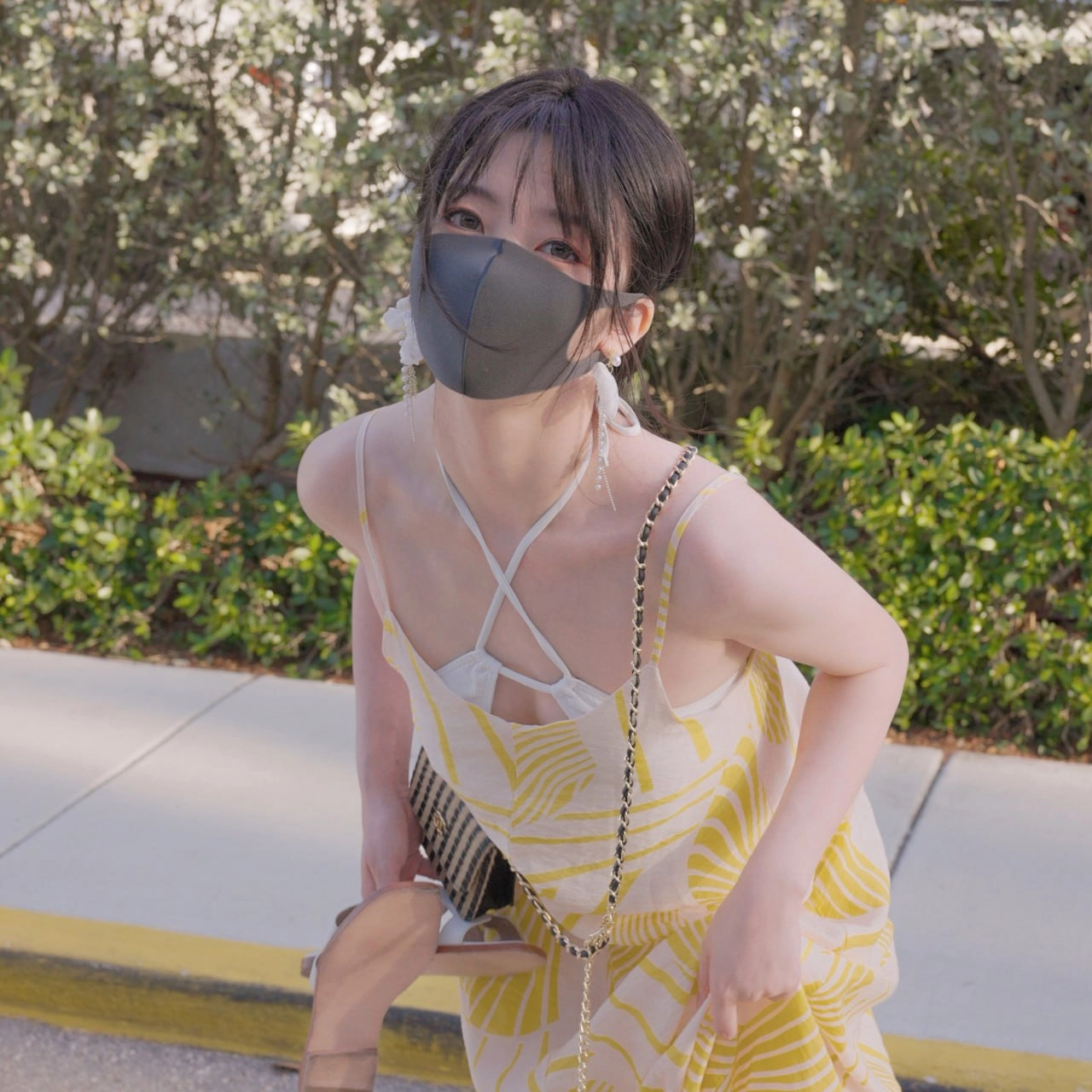 一位穿着黄色裙子的女人,带着手提袋,穿过一片森林。