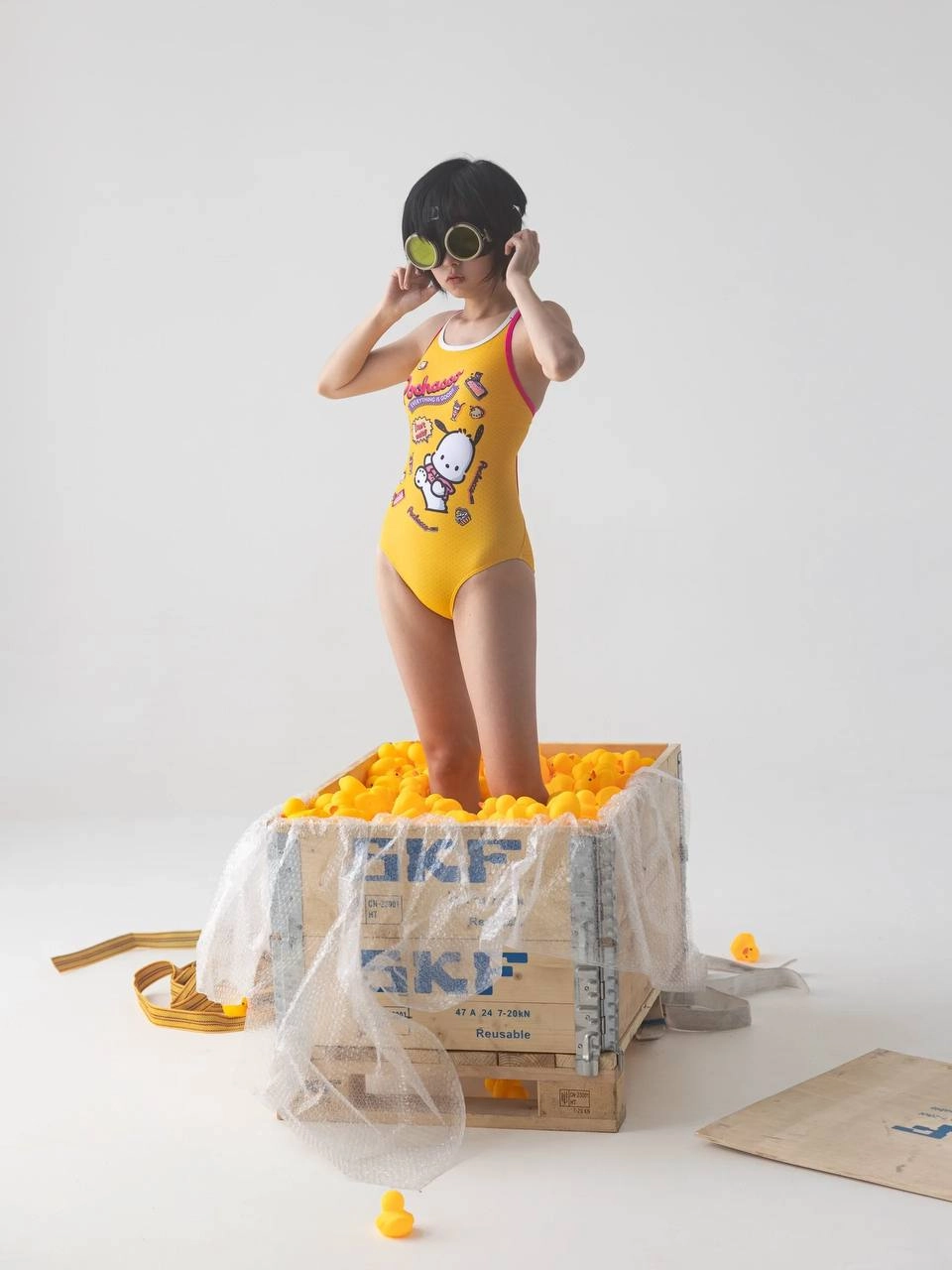 女孩在一个装满黄橡胶鸭子的盒子里。