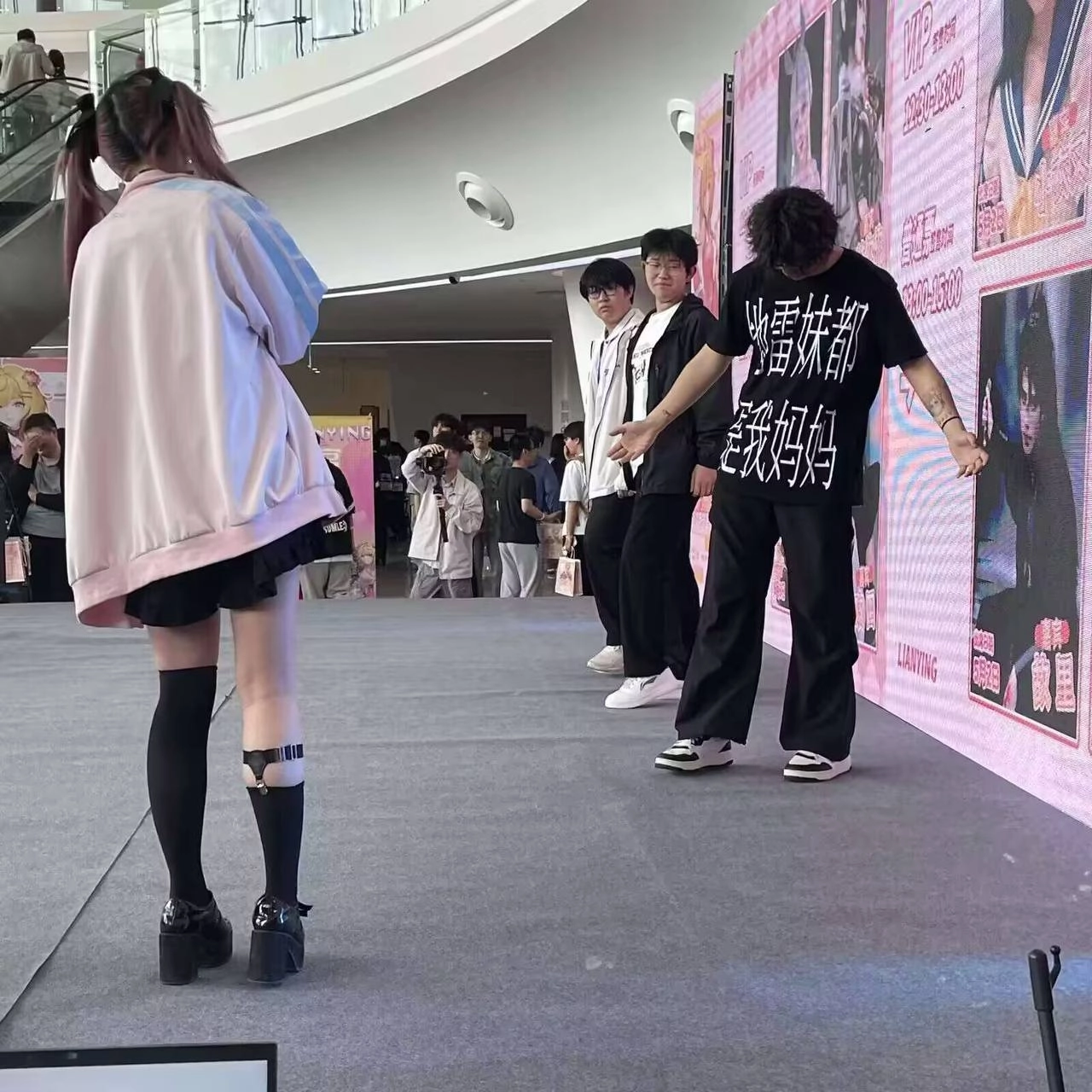 穿着黑色衬衫和白色鞋子的男人站在舞台上。