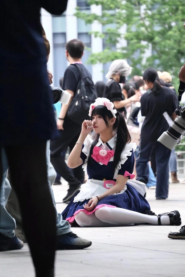 穿着女仆的服装的女人坐在地上。