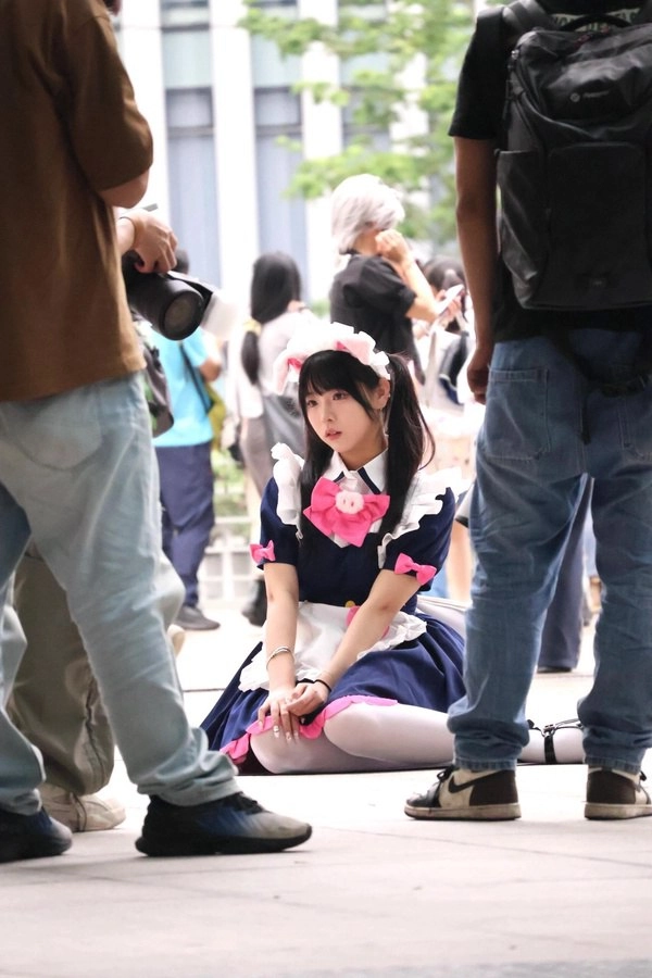 穿着女仆的服装的女人坐在地上。