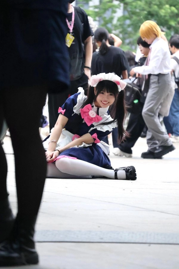 穿着女仆的服装的女人坐在地上。