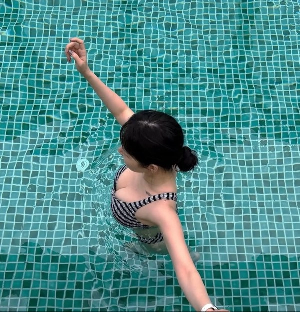 穿比基尼的女人在游泳池里游泳。