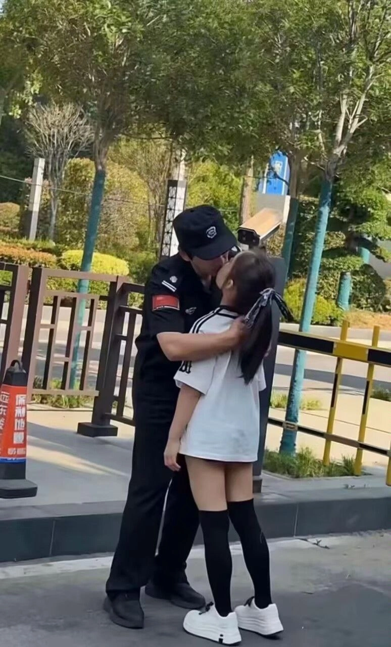 男人和一个女人在一个围栏前接吻。