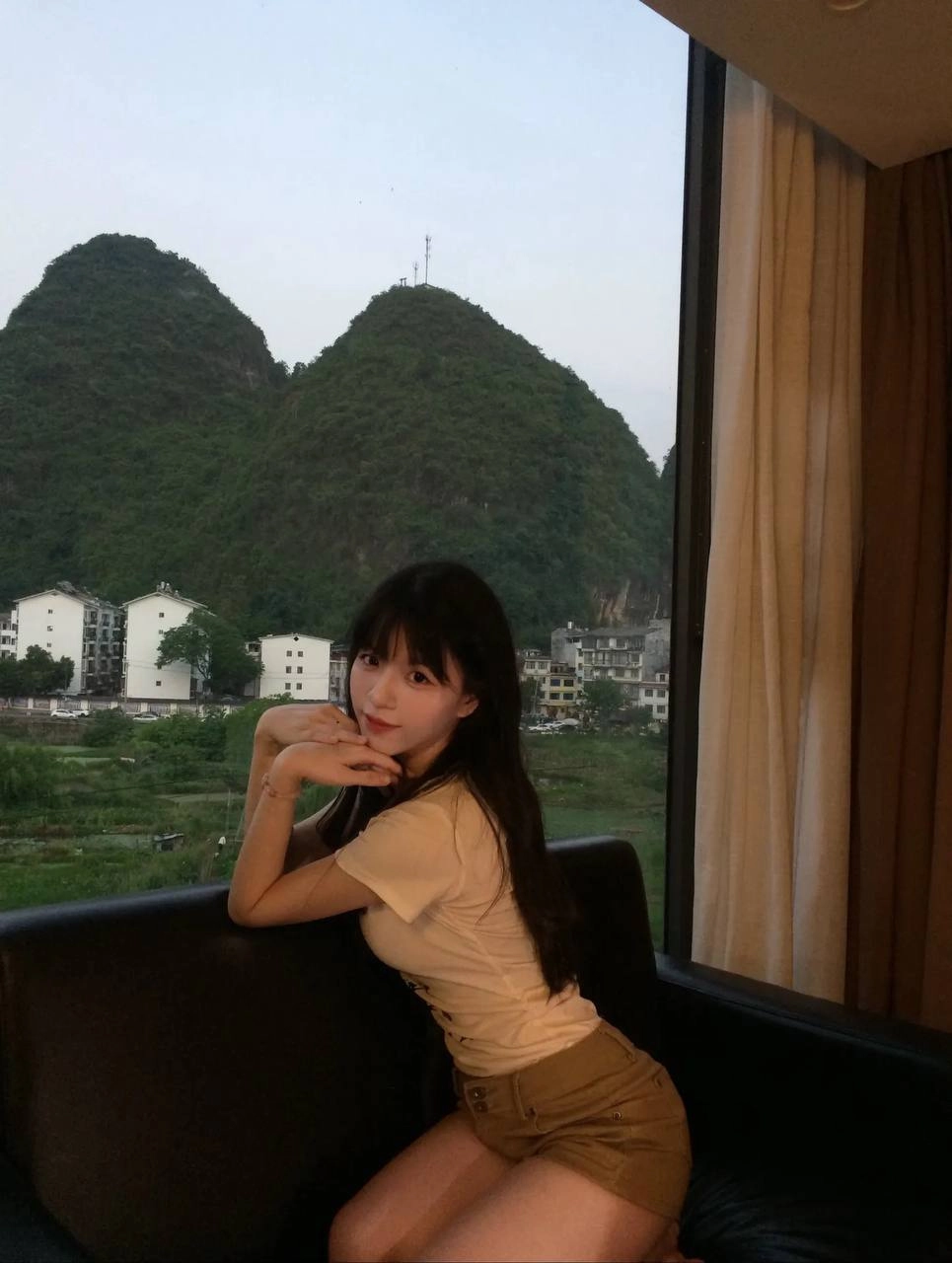 女人坐在沙发上,望着一座山。