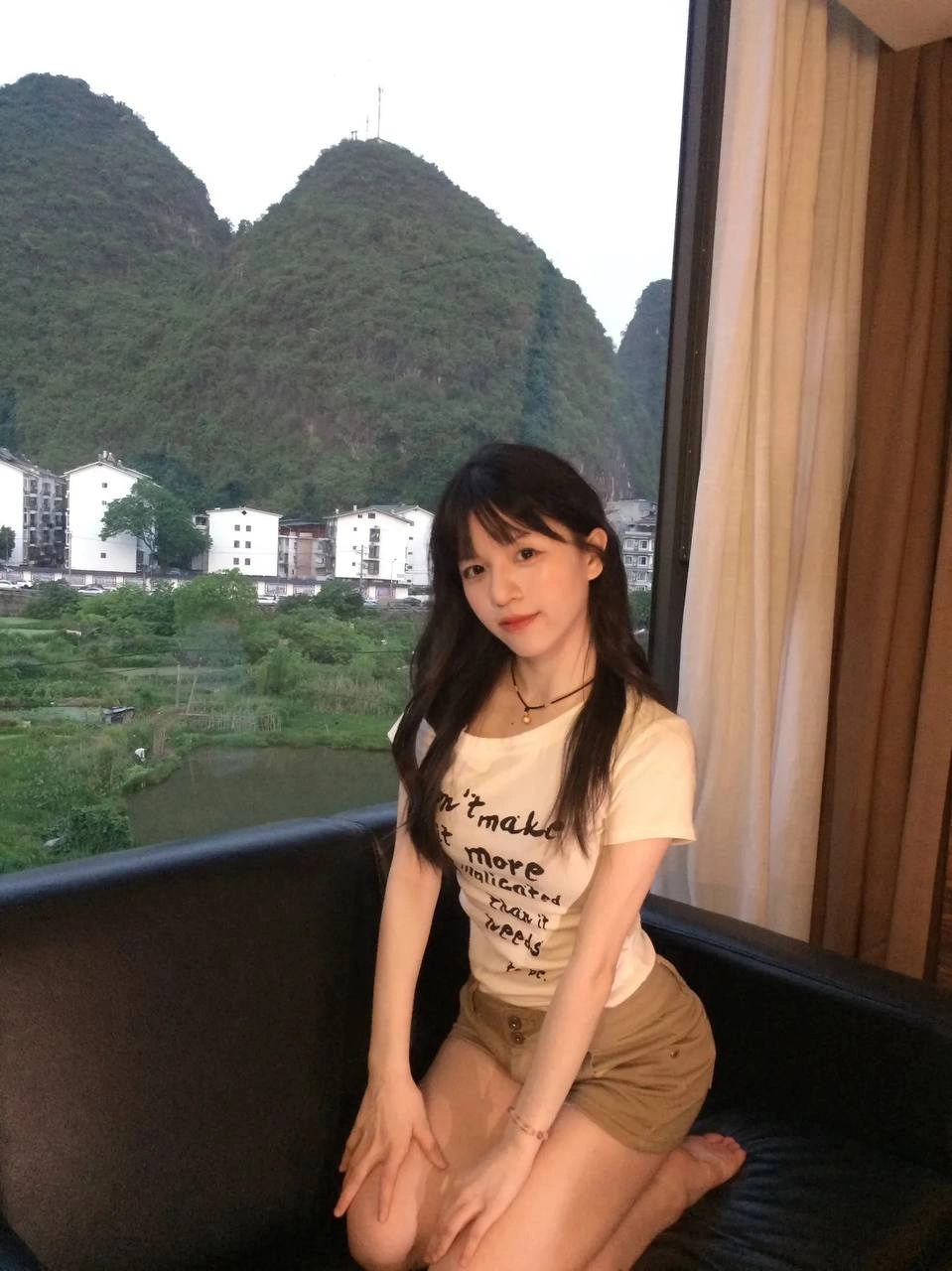 女人坐在沙发上,望着一座山。