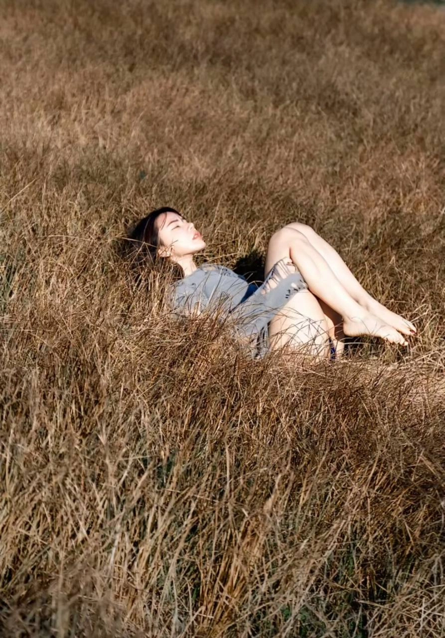 女人躺在高草上。