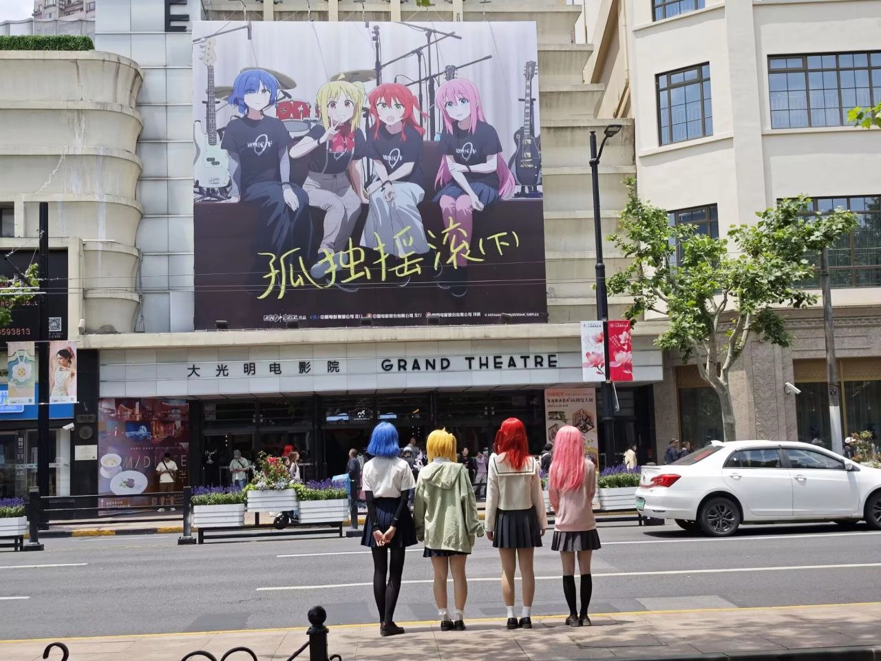 四个女孩站在一张大海报前面。