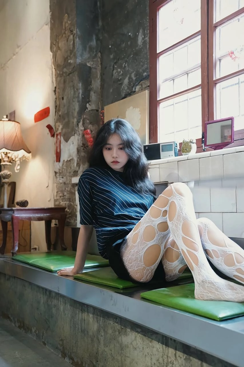 穿着白色裤子的女人坐在一个凳子上。