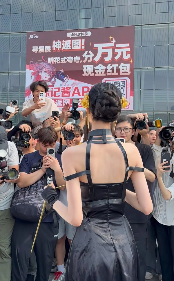 一位穿着黑色衣服的女人站在一群人面前拍照。