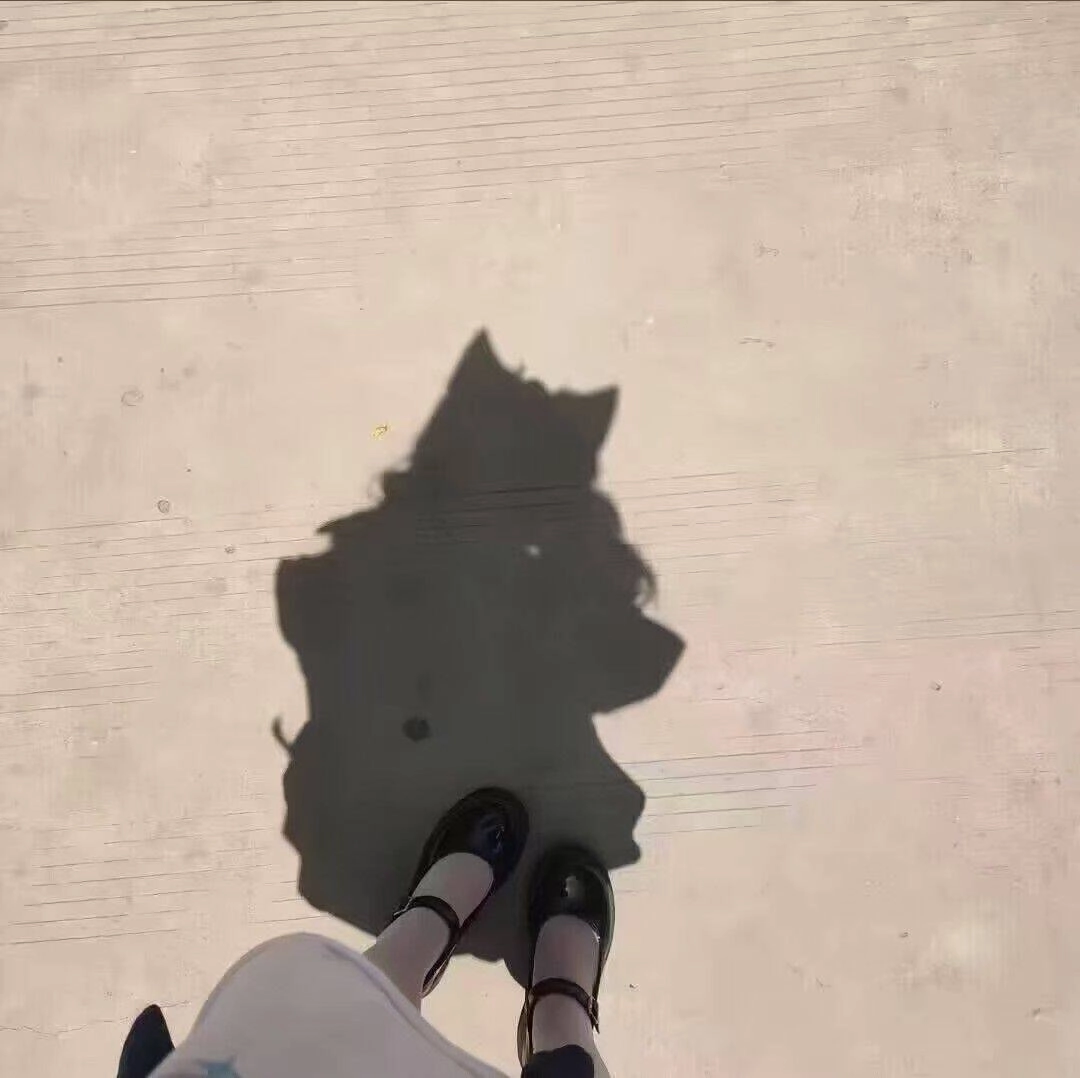 戴着帽子和外套的女人正在地上抛出一个影子。