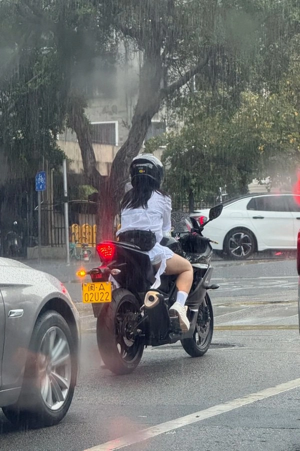 女人在雨中骑自行车。