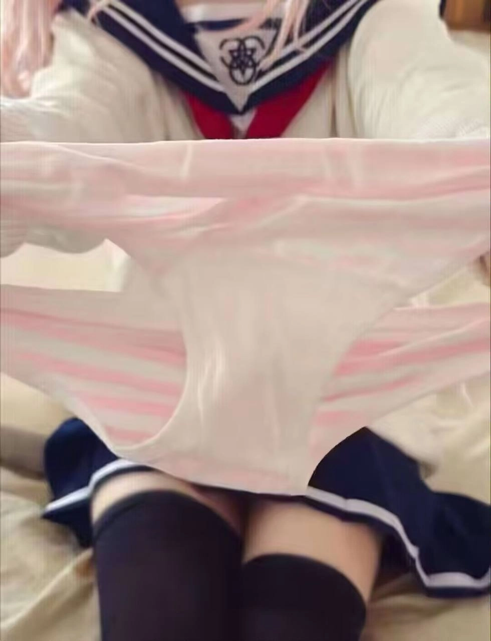 穿着白色衬衫和黑色裤子的女人抱着一双裤子。